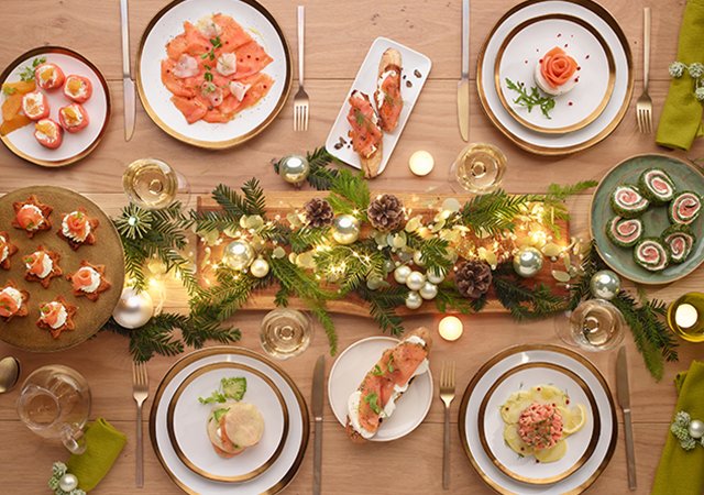 Table dressée avec mets au saumon et décorations festives.
