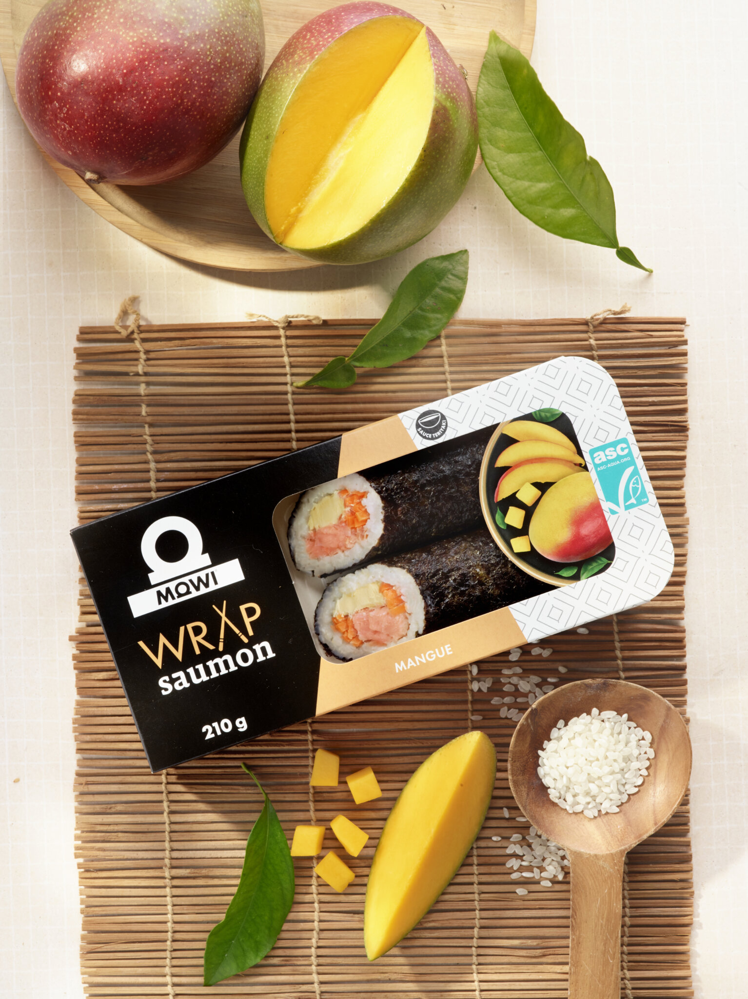 Wrap saumon mangue Mowi, deux mangues et des feuilles vertes.